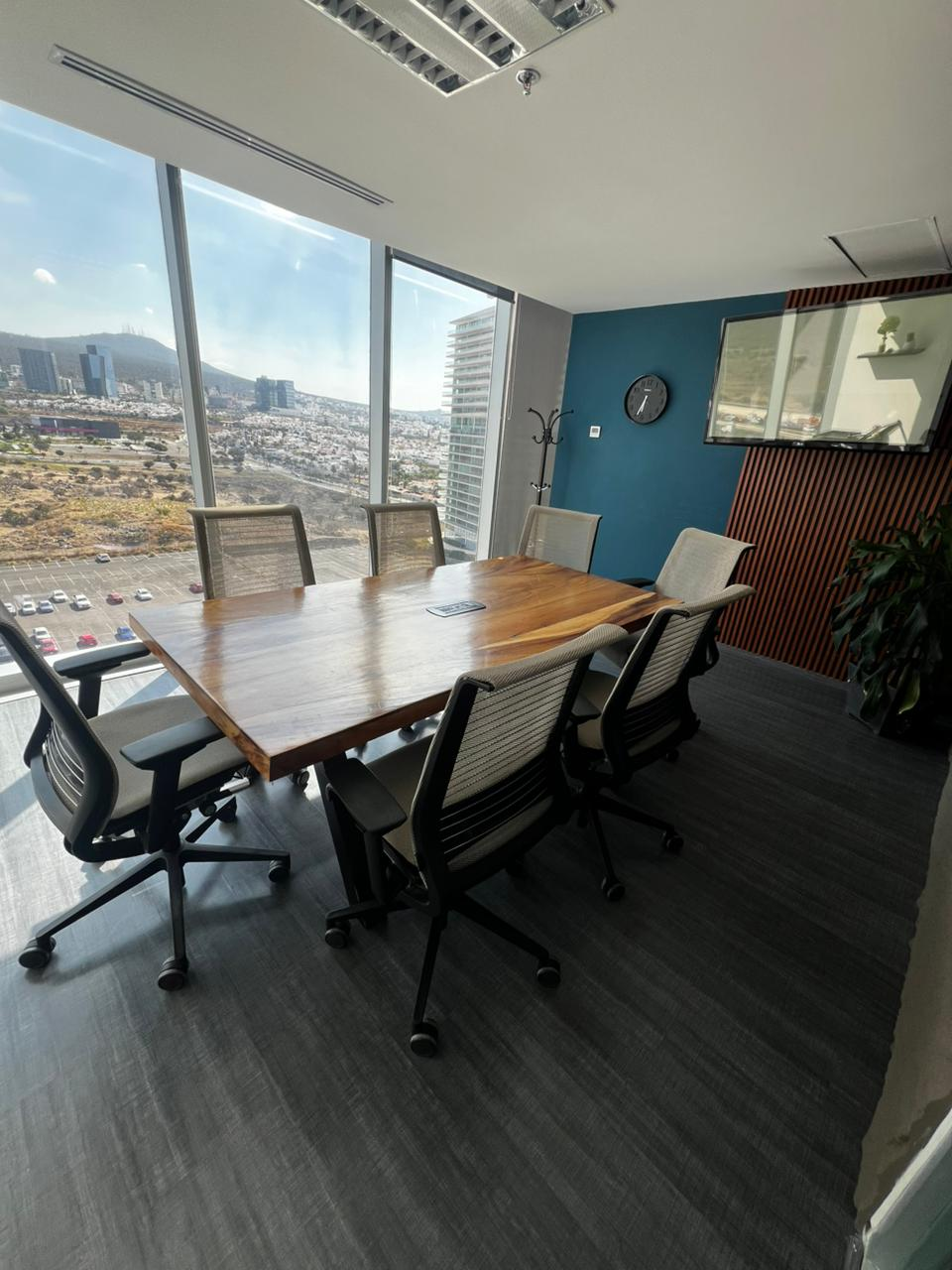Sala de juntas con mesa de madera y vista a la ciudad en RedCIMA